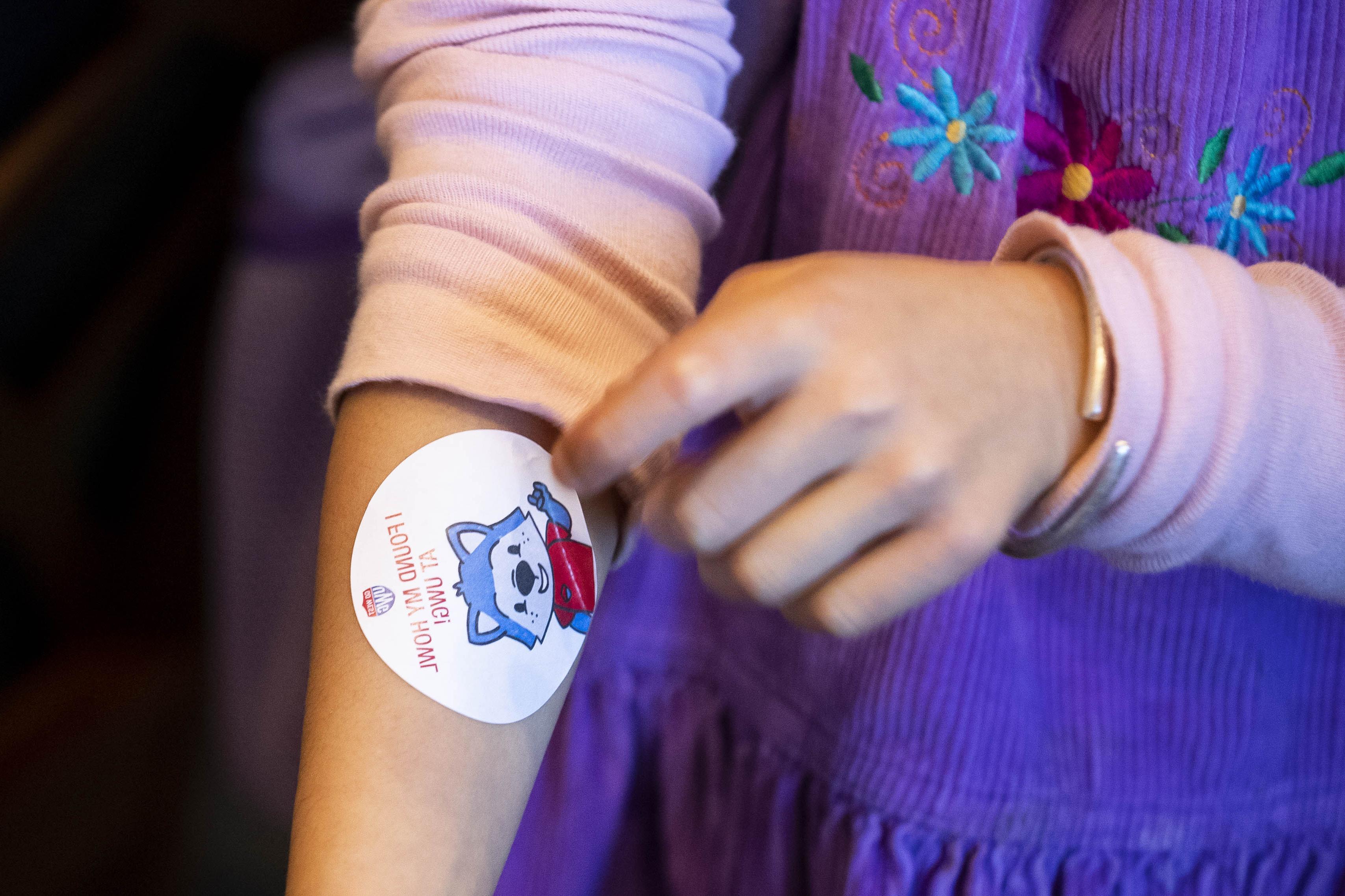 child with woflie sticker on her arm